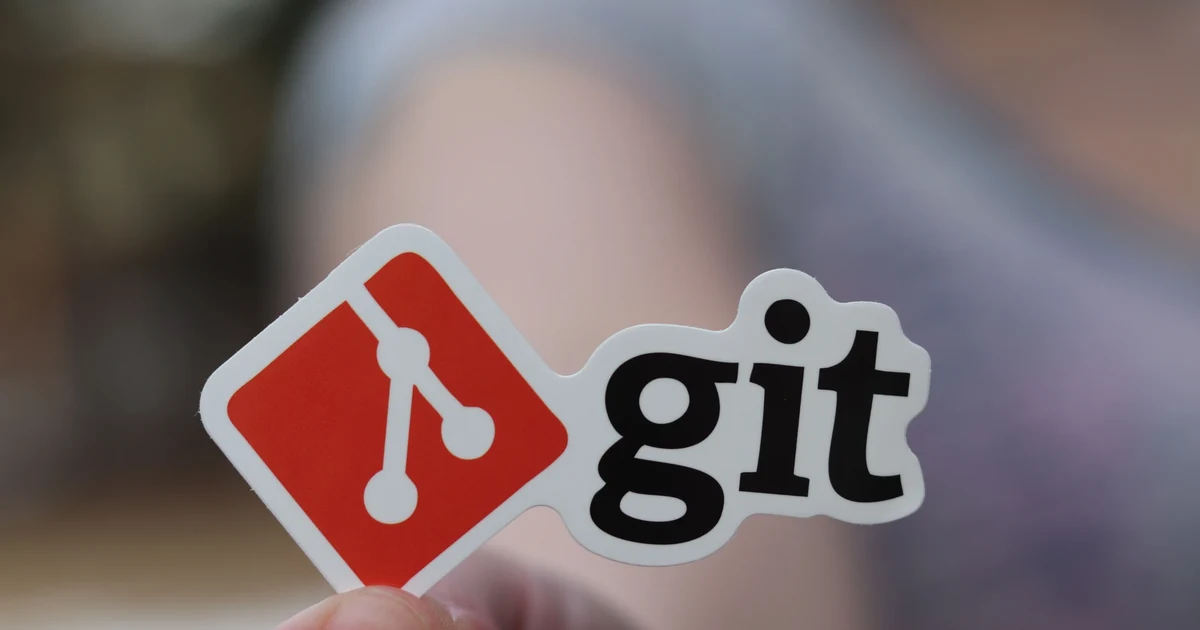 A git logo sticker held between two fingers